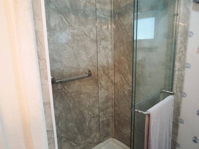 bathroom featuring a shower with door