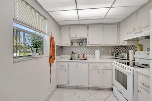 kitchen with light tile patterned flooring, sink, backsplash, and white range with electric cooktop