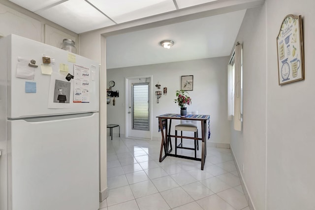 kitchen with light tile patterned flooring and white fridge