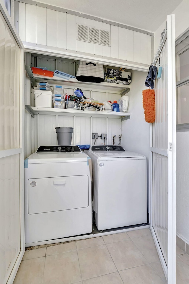 laundry room featuring light tile patterned flooring and separate washer and dryer