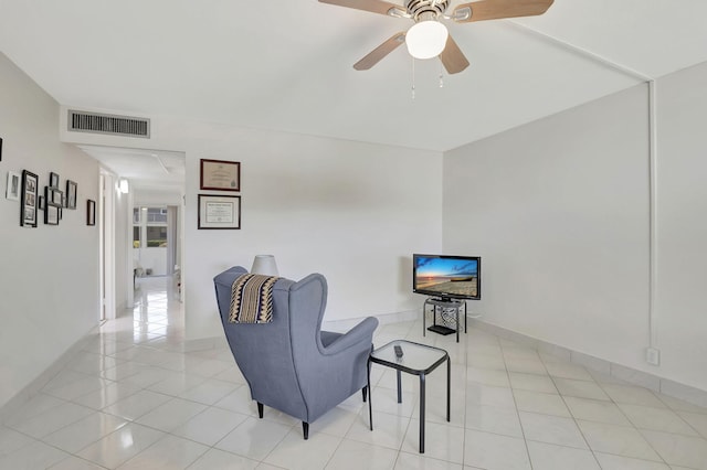 living area with light tile patterned floors and ceiling fan