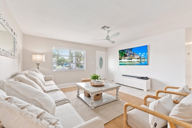 tiled living room featuring ceiling fan and a textured ceiling