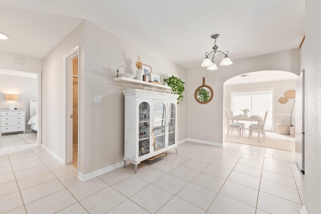 interior space featuring light tile patterned floors and a notable chandelier