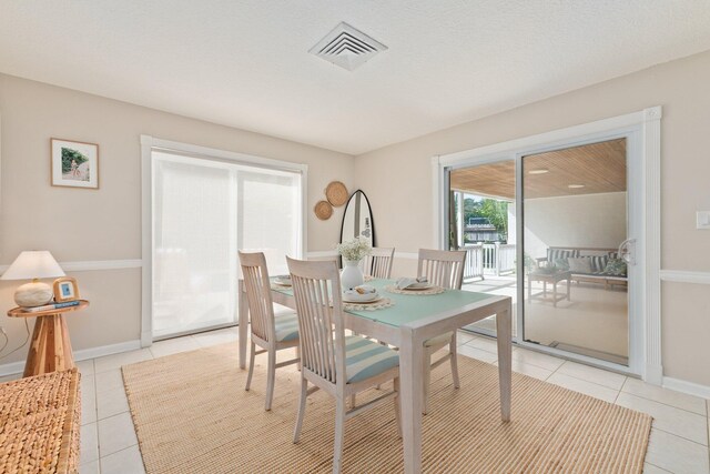 dining room with light tile patterned floors and a textured ceiling