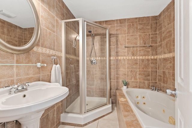 bathroom with tile patterned floors, separate shower and tub, sink, and tile walls