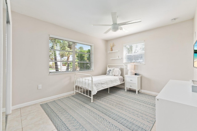 bedroom with ceiling fan, multiple windows, and light tile patterned flooring