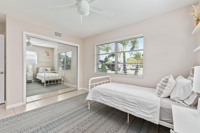 bedroom featuring light tile patterned floors, a closet, and ceiling fan