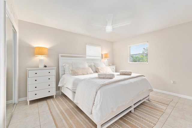 tiled bedroom featuring ceiling fan and a closet