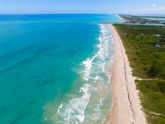 bird's eye view featuring a water view and a beach view