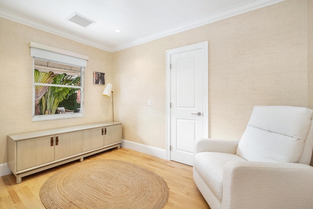 sitting room with light hardwood / wood-style floors and crown molding