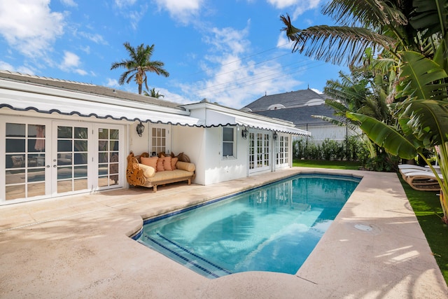 view of swimming pool with french doors and a patio