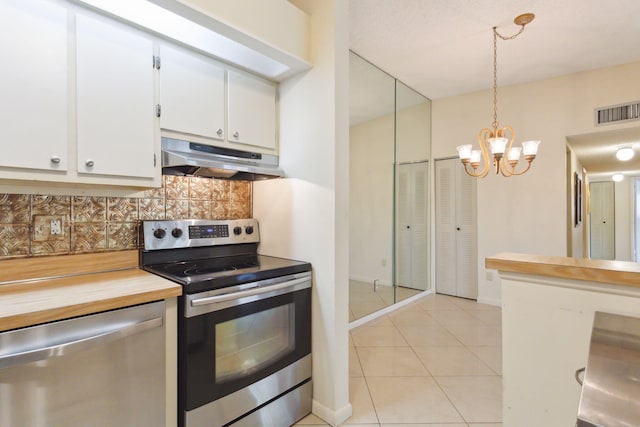 kitchen with backsplash, white cabinets, hanging light fixtures, light tile patterned floors, and appliances with stainless steel finishes