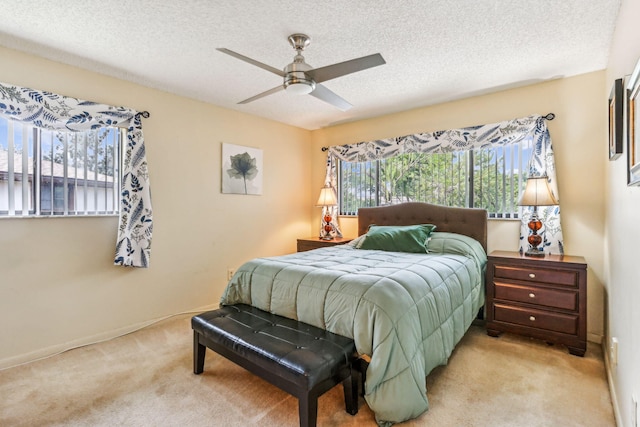 bedroom featuring ceiling fan, light carpet, and multiple windows