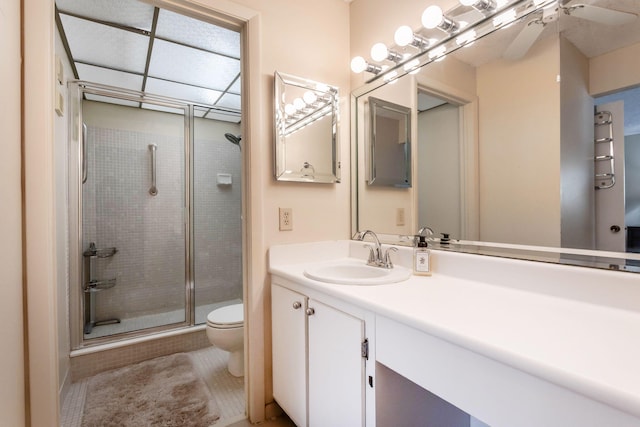 bathroom with an enclosed shower, vanity, and toilet