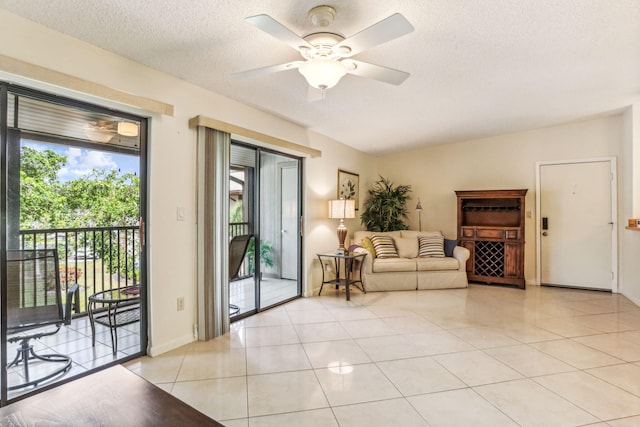 tiled living room featuring ceiling fan and a textured ceiling