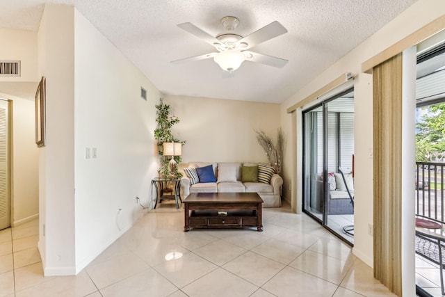 tiled living room with ceiling fan and a textured ceiling