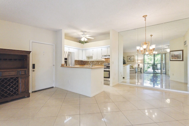 kitchen featuring pendant lighting, backsplash, white cabinets, kitchen peninsula, and stainless steel appliances