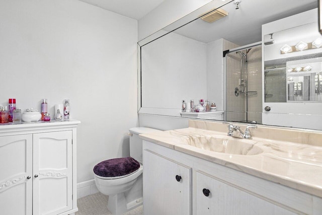 bathroom with tile patterned floors, vanity, toilet, and a shower with shower door