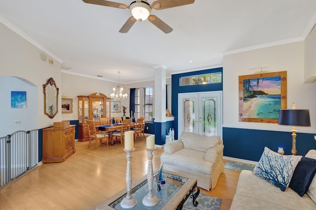 living room featuring french doors, ceiling fan with notable chandelier, light hardwood / wood-style flooring, and crown molding