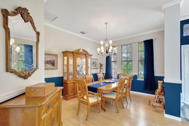 dining space with an inviting chandelier, ornate columns, light wood-type flooring, and crown molding