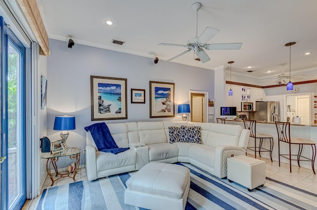 living room with light hardwood / wood-style floors, ceiling fan, and crown molding