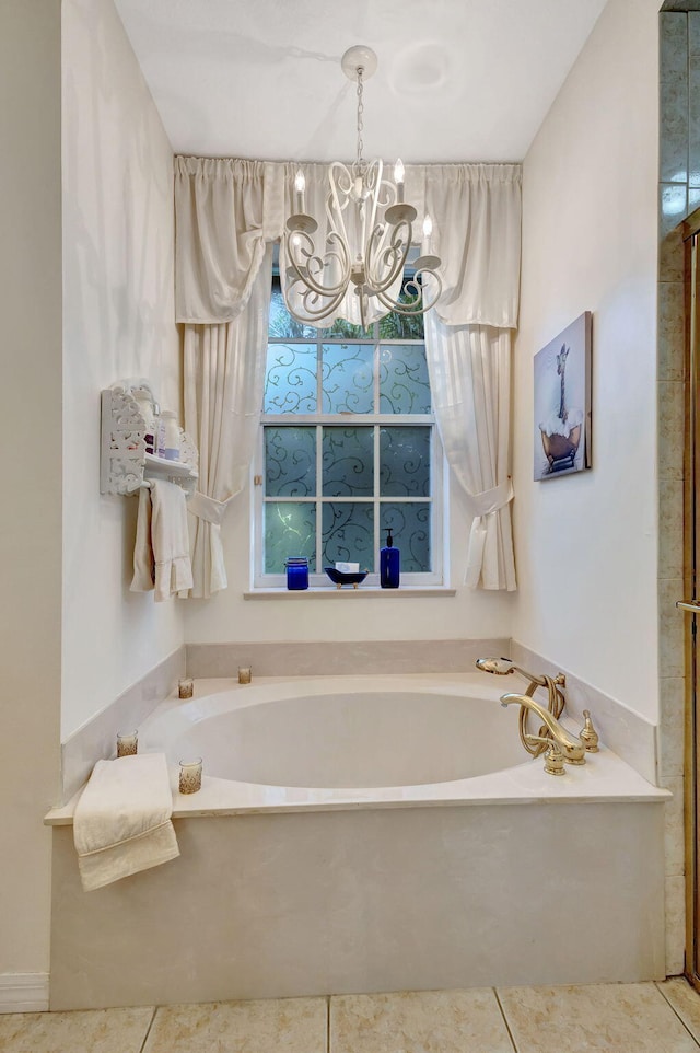 bathroom with tile patterned flooring, a tub, and an inviting chandelier