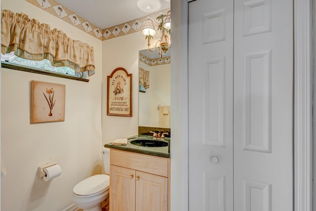 bathroom featuring vanity, toilet, and a textured ceiling