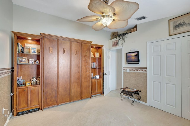 carpeted bedroom featuring ceiling fan and a closet