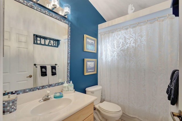 bathroom featuring toilet, vanity, and vaulted ceiling