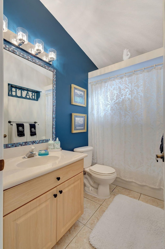 bathroom with toilet, lofted ceiling, tile patterned floors, and vanity