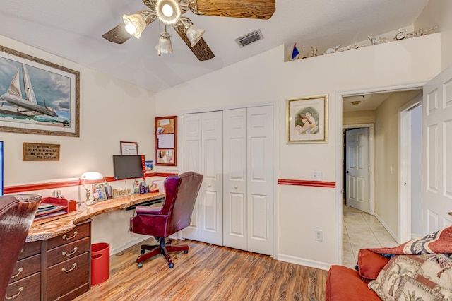 home office featuring light hardwood / wood-style floors, lofted ceiling, built in desk, and ceiling fan