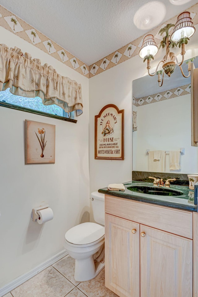 bathroom featuring toilet, vanity, a textured ceiling, and tile patterned floors