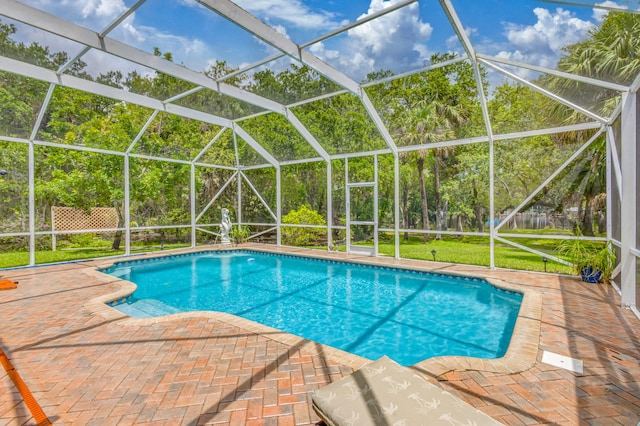 view of swimming pool featuring a patio area, a yard, and a lanai