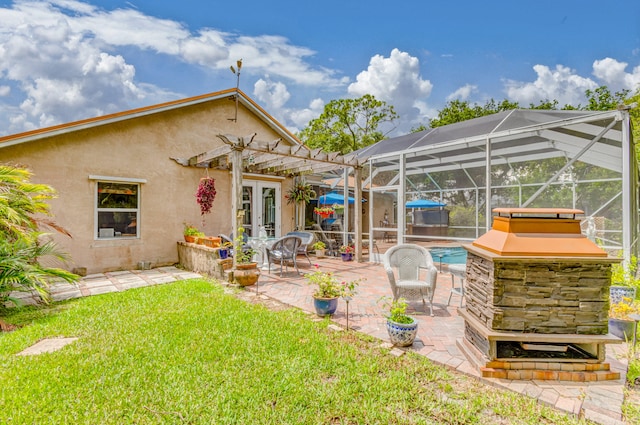 rear view of house featuring french doors, glass enclosure, a yard, and a patio area