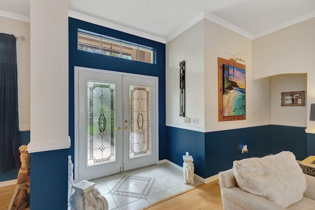 entrance foyer with ornamental molding, french doors, and light hardwood / wood-style floors