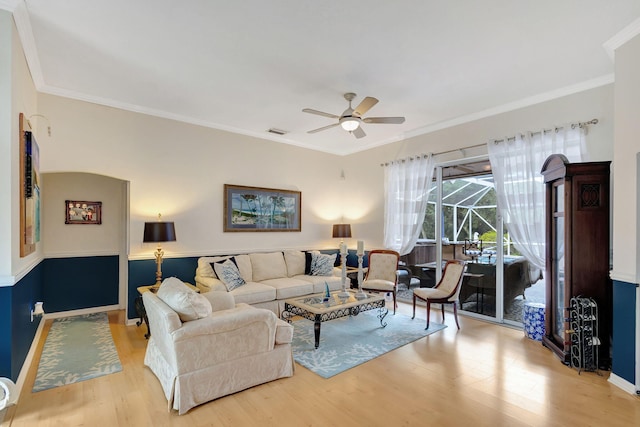 living room with light wood-type flooring, ceiling fan, and crown molding