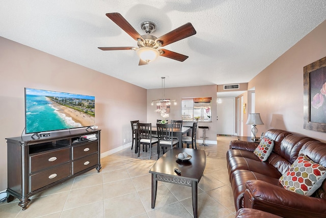 tiled living room featuring ceiling fan and a textured ceiling