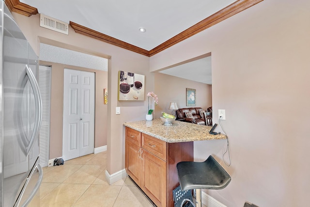 kitchen with kitchen peninsula, stainless steel refrigerator, light stone countertops, crown molding, and light tile patterned flooring