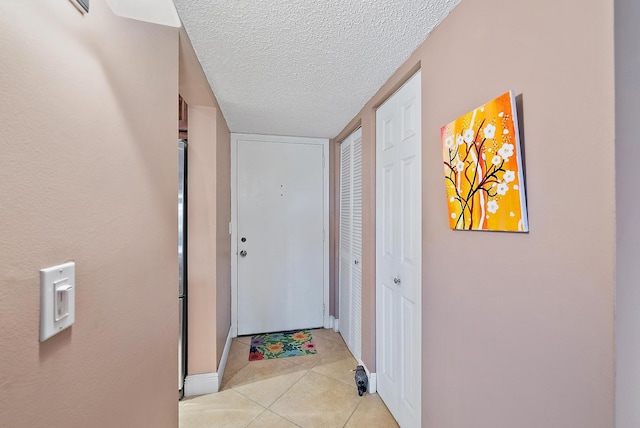 entryway featuring a textured ceiling and light tile patterned floors