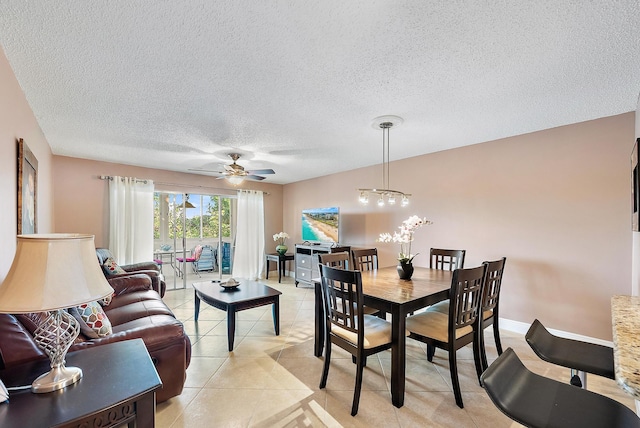 tiled dining room featuring a textured ceiling and ceiling fan