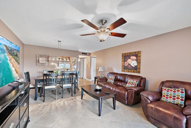 tiled living room with ceiling fan and a textured ceiling