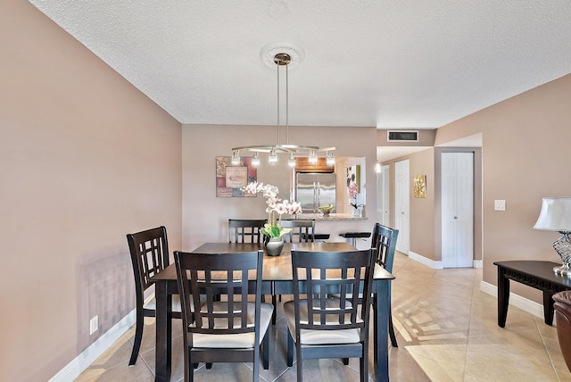 tiled dining room with a textured ceiling