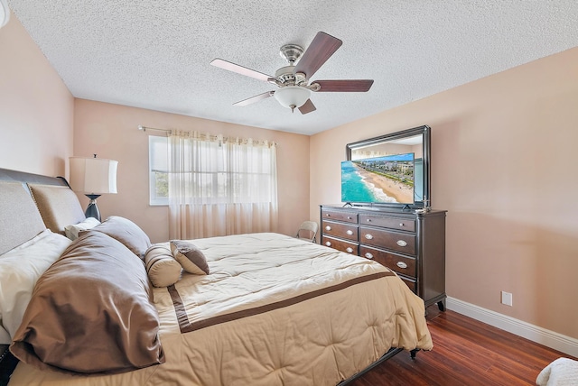 bedroom with ceiling fan, dark hardwood / wood-style floors, and a textured ceiling