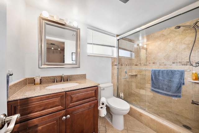 bathroom featuring vanity, tile patterned flooring, toilet, and walk in shower