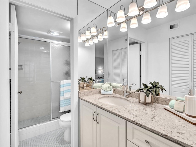 bathroom with tile patterned flooring, vanity, toilet, and a shower with shower door