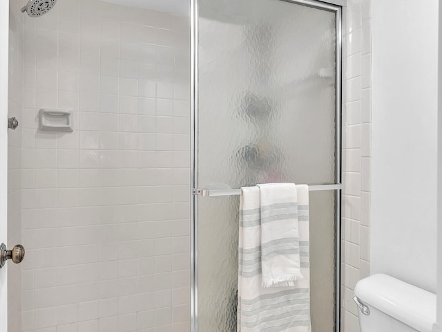 bathroom featuring an enclosed shower and toilet