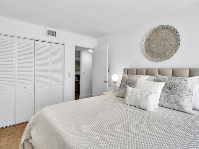 bedroom with light hardwood / wood-style flooring and a closet