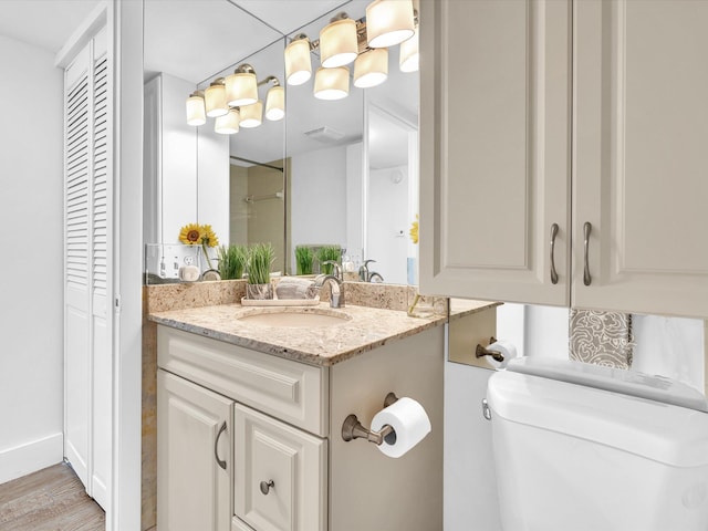 bathroom with hardwood / wood-style floors, vanity, and toilet