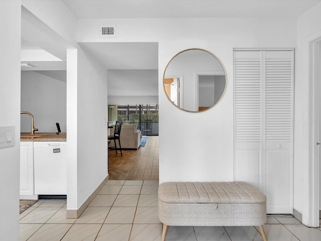 hall with light hardwood / wood-style flooring and sink