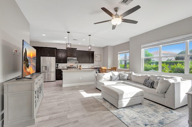 living room with ceiling fan and light hardwood / wood-style floors